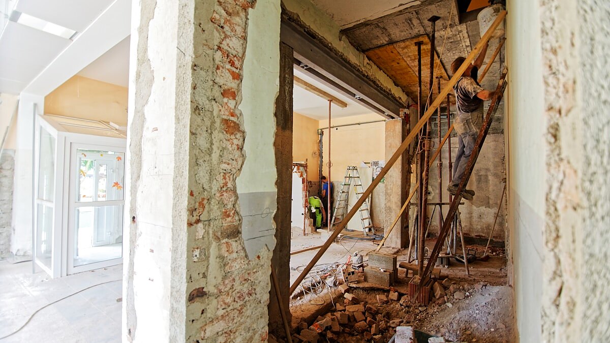 Tradesperson working on an interior home renovation with ladder and protected floors